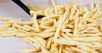 Fast food, french fries and spatula for lifting chips, serving potato or dish ingredients at restaurant. Salted carbs for meal, snack or fresh crispy cut cuisine on table for eating or customer