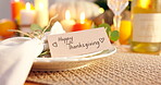 Happy thanksgiving, giftcard and table decoration for celebration dinner on holiday, care and event in apartment. Plate, napkin and wine glass for party preparation with centrepiece and lunch in home