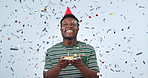 Happy birthday, confetti and black man in celebration with cake isolated in studio blue background for party. Happiness, wow and excited person winning giveaway, prize and gift or present reward