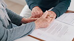 Holding hands, insurance and finance with a senior couple closeup in their home for accounting or budget. Stress, tax or debt with an elderly man and woman reading information for pension or will