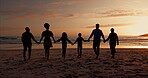 Big family silhouette, walking on beach and hands together for support, holiday and summer vacation in sunset. Back of grandparents and kids by ocean, sea or nature for love, care or outdoor wellness