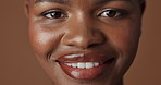 Face of black woman, natural beauty or glow for wellness, cosmetics or healthy skin in studio. Dermatology, closeup or happy African girl model with smile or skincare results on brown background