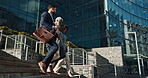 Business people, stairs and outdoor in city with conversation for travel, commute or walking to work. Employee, professional and colleague with briefcase, communication and happy on steps by building