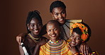 Fashion, beauty and heritage with group of black women in studio on brown background together for support. Portrait, smile and culture with happy African people in clothes of tradition for community