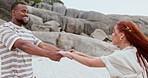 Holding hands, happy and couple playing at the beach on vacation, adventure or holiday together. Love, smile and young woman and man having fun and bonding by the ocean or sea on weekend trip.