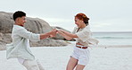 Holding hands, love and couple playing at the beach on vacation, adventure or holiday together. Happy, smile and young woman and man having fun and bonding by the ocean or sea on weekend trip.