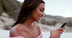 Woman, smile and typing with phone at beach for social media blog, reading notification and chat on holiday, vacation and travel, Happy indian girl scroll on smartphone at ocean for mobile contact