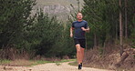 Man, fitness and running on path in woods for exercise, workout and energy of performance in nature, environment or garden trail. Strong runner training for cardio marathon, power or action in forest