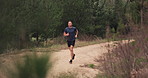 Man, exercise and running on path in nature for fitness, workout and energy in woods, environment and sand trail. Strong runner training for cardio marathon, power or action of healthy pace in forest