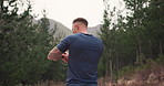 Man, fitness and smartwatch in forest for running, training and workout progress, goals and break on hiking path. Back of runner or sports person with timer, stopwatch or time for exercise in nature