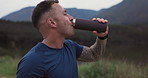 Man, fitness and drinking water in nature for sports break, energy and workout performance in environment. Thirsty runner with bottle for hydration, nutrition or healthy recovery for outdoor exercise