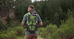 Man, backpack and walking in nature for travel adventure, wellness and fitness or on a hiking journey. Back of hiker or person trekking in a forest and mountains for exercise and eco friendly tourism