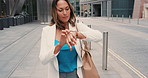 Mature hispanic woman checking time on her watch in the city