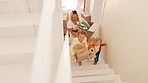 Moving, parents and children on stairs in new home with toys, excited and mortgage on property investment. Mother, father and kids together at front door house with boxes, teddy bear and real estate