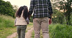 Father, child and hand holding in outdoor nature on holiday adventure for bonding, travel or explore. Male person, kid and back view in forest for hiking trekking journey for workout, health or peace