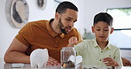 Man, boy and savings with coins in home, counting and lesson on money as positive childhood habits. Father, son or bonding together by piggy bank, love or teaching financial investment to grow wealth