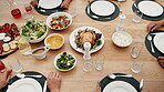 Hands, food on table for thanksgiving and people together in home for celebration event of tradition. Family, party or gathering with an adult group in an apartment, bonding over meal from above