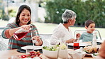 Family, thanksgiving and grandma with mother or child at table outdoor for celebration or tradition. Happy, food or lunch with parent, senior woman and kid eating meal together in a social gathering