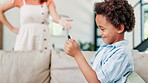 Discipline, mother and kid with phone playing game, addiction and happy African family in home living room sofa. Punishment, child and parent take away smartphone, dependency and abuse of technology