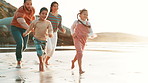 Family, game and running on beach at sunset playing with freedom, happiness and travel on holiday. Summer, vacation and parents bonding, chasing or catch children together on sand for fun adventure