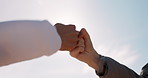 Hands, friends and fist bump outdoor for greeting, partnership or celebration for success with blue sky. People, teamwork and collaboration with support, agreement and team building with lens flare