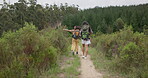 Friends, women in woods and hiking, back in nature and point at view with walking and travel together. Adventure, journey and fitness, sightseeing in park for tourism, environment and backpacking