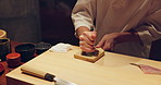 Sushi, food and closeup of chef hands cooking on table at diner, cuisine or restaurant at night. Kitchen, career and zoom of culinary artist preparing a gourmet Japanese meal or snack at catering job