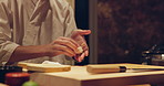 Sushi chef hands, fish and rice with meal preparation on table at diner, cuisine and cooking in night. Person, kitchen or restaurant with catering job, ready and service for nutrition, diet or snack