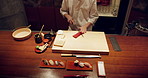 Sushi, fish and closeup of chef hands cooking on table at diner, cuisine or restaurant at night. Kitchen, knife and zoom of culinary artist preparing a gourmet Japanese meal or snack at catering job.