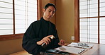 Black ink, Asian man or Japanese artist in studio for art and script, calligraphy with paper for alphabet. Start, ready or creative person with tools, paintbrush and focus with traditional stationery