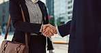 Business people, handshake and city for greeting, partnership or agreement in outdoor deal or meeting. Closeup of employees shaking hands outside for b2b, teamwork or hiring in an urban town together