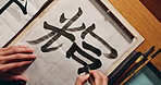 Top, Asian writing or script with brush and ink, calligraphy or ancient Japanese font with stationery and stroke. Writer, person with traditional or vintage tools for letter or alphabet with closeup