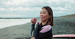 Surfer woman, stretching and training by ocean, smile and ready for workout, exercise or wellness in morning. Person, happy and excited at beach, waves and nature with health, back and arms in Japan