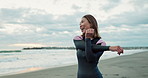 Surfer woman, stretching and exercise at beach, smile and ready for workout, training or wellness in morning. Person, happy and excited by ocean, waves and nature for health, muscle or arms in Japan