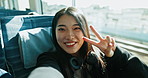 Happy asian woman, video call and train with peace sign for social media, travel or memory in public transport. Portrait of female person, face or smile while waving hand for hello on railway line