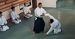 Aikido, class and fight with a master in martial arts with student in self defence, discipline and training. Technique, demonstration or Japanese sensei with black belt skill in fighting or education