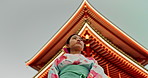 Woman, Japanese shinto temple and traditional clothes for culture, building or religion in sunshine. Person, ideas and vision for buddhism with faith, mindfulness or thinking with low angle in Kyoto