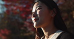 Outdoor, thinking and Asian woman with a smile, nature and forest with joy, daydreaming and holiday. Japanese person sunshine or girl with summer, travel or peace with vacation. calm or weekend break