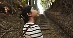 Woman, walking and thinking in forest for hiking, travel adventure and freedom in nature from the back. Japanese tourist with bag in environment, jungle path and wonder in woods, park and eco garden