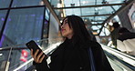 Japanese woman on city escalator with phone, internet and connection on morning commute. Search, schedule and travel, Asian girl in mall checking email or post on smartphone app on journey in Tokyo.