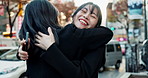 Women, hugging in city or smartphone for communication on social network, greeting or meet friend in town on street. Japan, people or embrace by mobile for travel, leisure or technology by outdoor