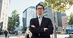 Japanese businessman, face and arms crossed in city, glasses and smile in ambition in corporate career. Young person, portrait and entrepreneur for confident with vision and formal suit in urban town