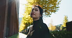 Asian, woman and smile in city for travel and view with lens flare, commute and adventure. Cityscape, metropolis or metro with Tokyo environment, urban street and journey with happiness and sunshine