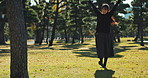 Asian, woman and freedom in park with happiness, sunshine and energy for wellness, smile and walk outdoor. Trees, nature and smile, care free in public garden in Japan and positivity with fresh air