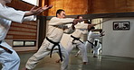 Black belt students, stick or learning martial arts in dojo for practice, aikido movement or self defense. Combat demonstration, Japanese people or training workout for fighting, education or class
