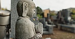 Garden statue in traditional Japanese graveyard with peace, calm and quiet landscape with memorial tombstone. Stone Buddha monument in outdoor cemetery with zen, Asian culture and spiritual history.