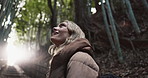 Nature, trees and young woman with adventure in woods for sightseeing or journey on weekend trip. Field, wonder and female person looking at plants in an outdoor forest on holiday or vacation