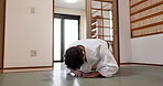 Martial arts student, man or bow in dojo for aikido practice, discipline or self defense in class. Respect, floor or male Japanese person learning combat or training workout for fighting or education