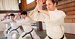 Aikido students, fitness or learning martial arts in dojo for practice, body movement or self defense. Combat demonstration, people or training workout for fighting, education or black belt class