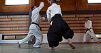 Student in dojo with sensei for aikido fight training, fitness and development with action, exercise and coaching. Teaching, learning and men in traditional Japanese martial arts class with aikidoka.